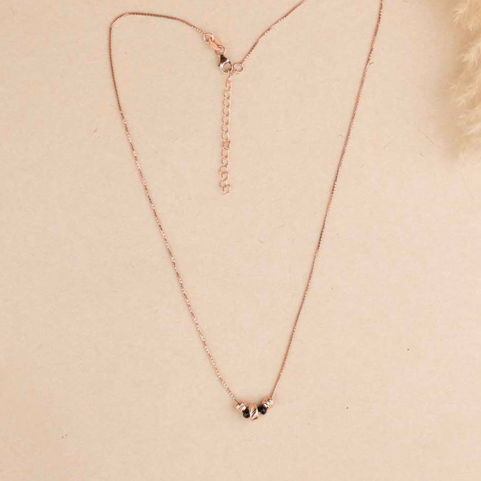 Necklace with small pendants on a beige background