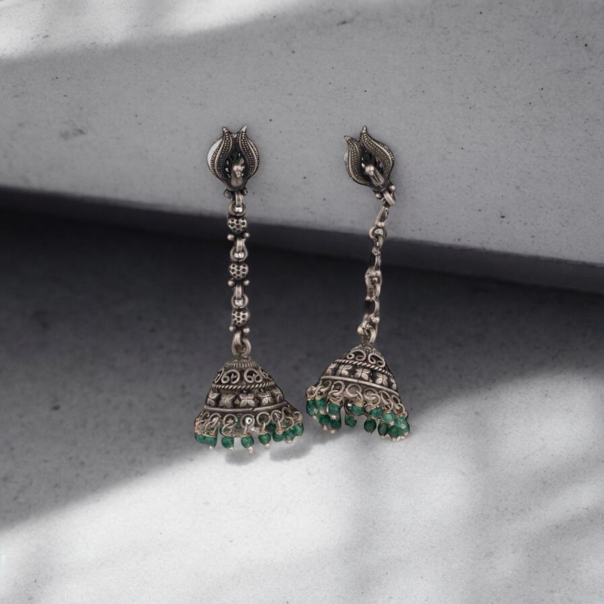 Intricately designed silver oxidized jhumka earrings with a traditional and vintage-inspired charm.