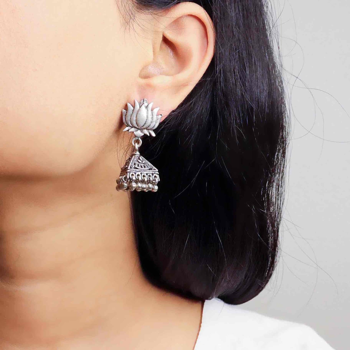 Intricately designed silver oxidized jhumka earrings with a traditional and vintage-inspired charm.