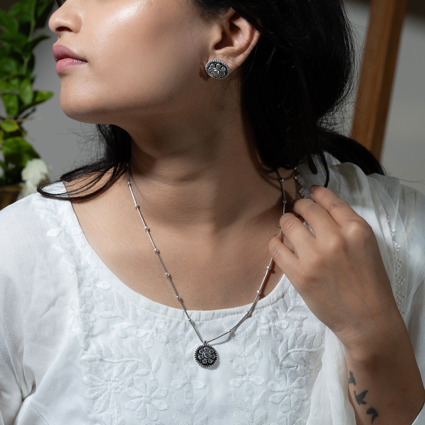 Delicate silver pendant necklace with a sparkling gemstone, set on a fine silver chain."