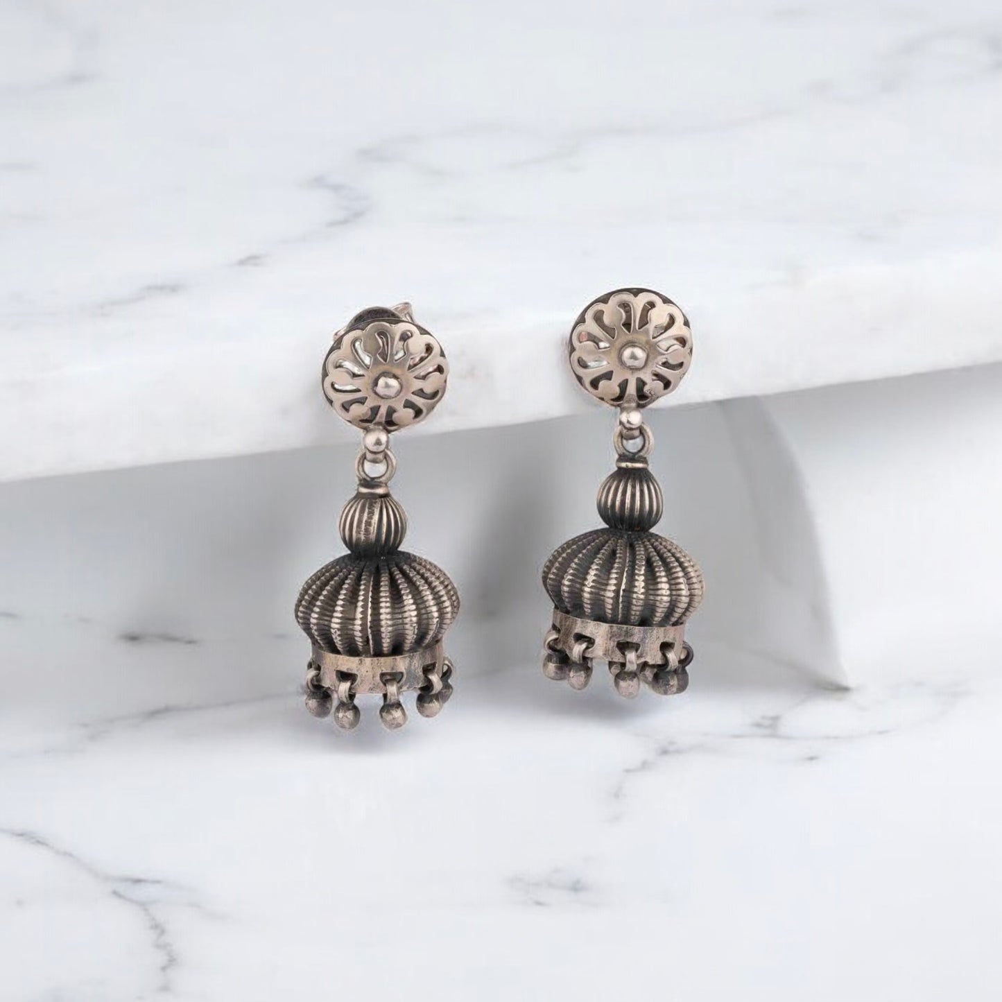 Intricately designed silver oxidized jhumka earrings with a traditional and vintage-inspired charm.