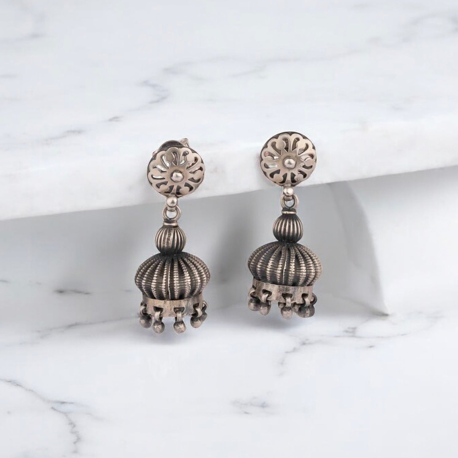 Intricately designed silver oxidized jhumka earrings with a traditional and vintage-inspired charm.