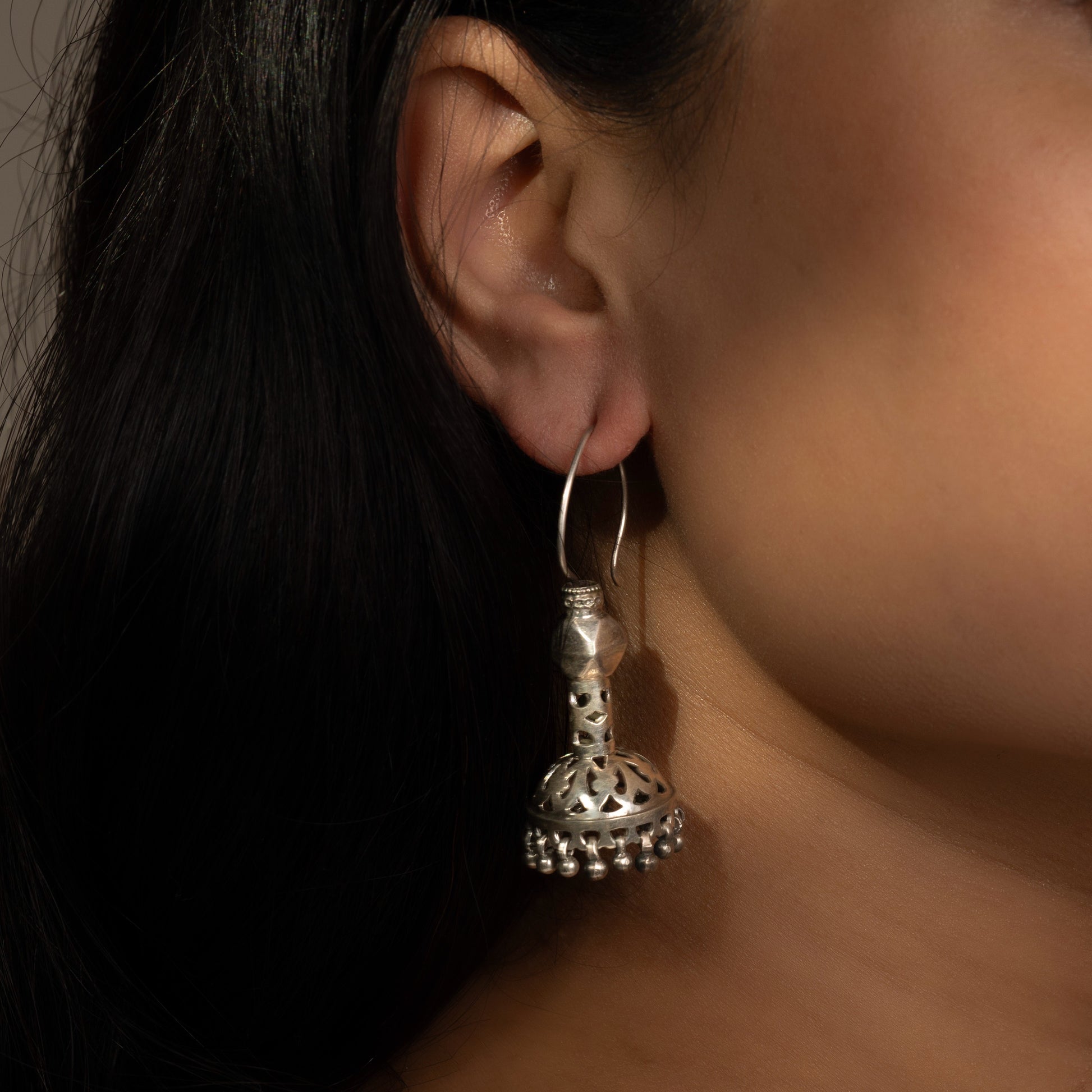 Intricately designed silver oxidized jhumka earrings with a traditional and vintage-inspired charm.