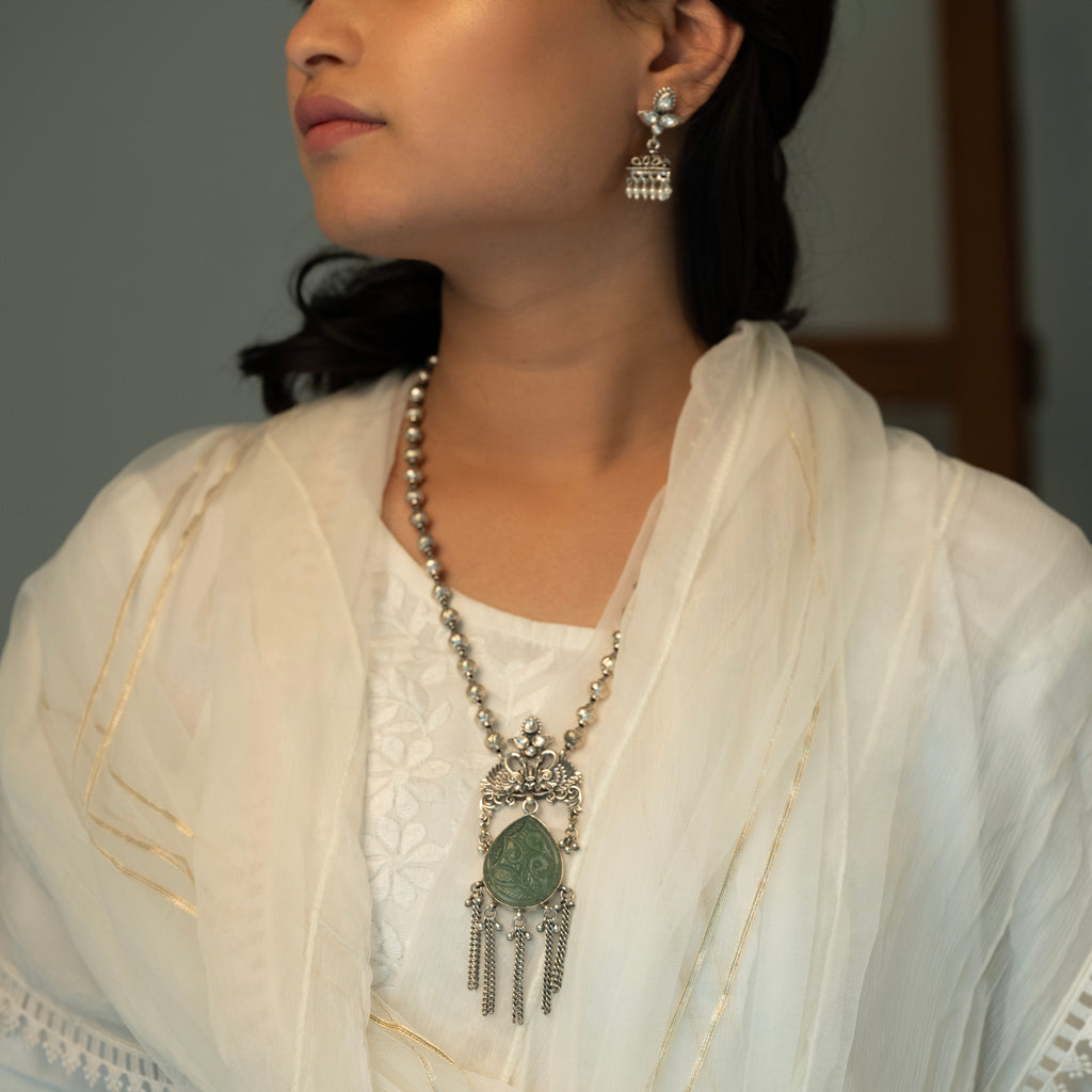 Long sterling silver necklace with a big green colour stone at centre, adding a touch of sophistication to any outfit