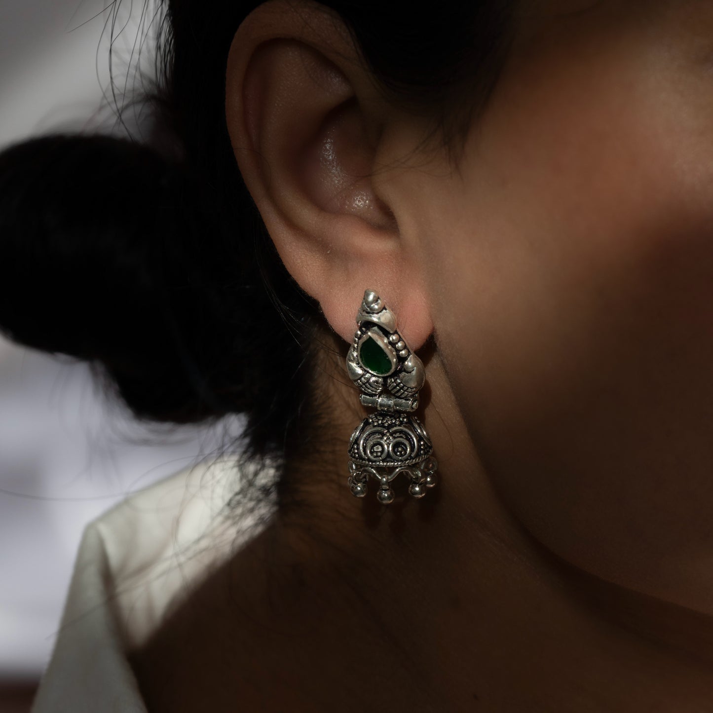 Intricately designed silver oxidized jhumka earrings with a traditional and vintage-inspired charm.