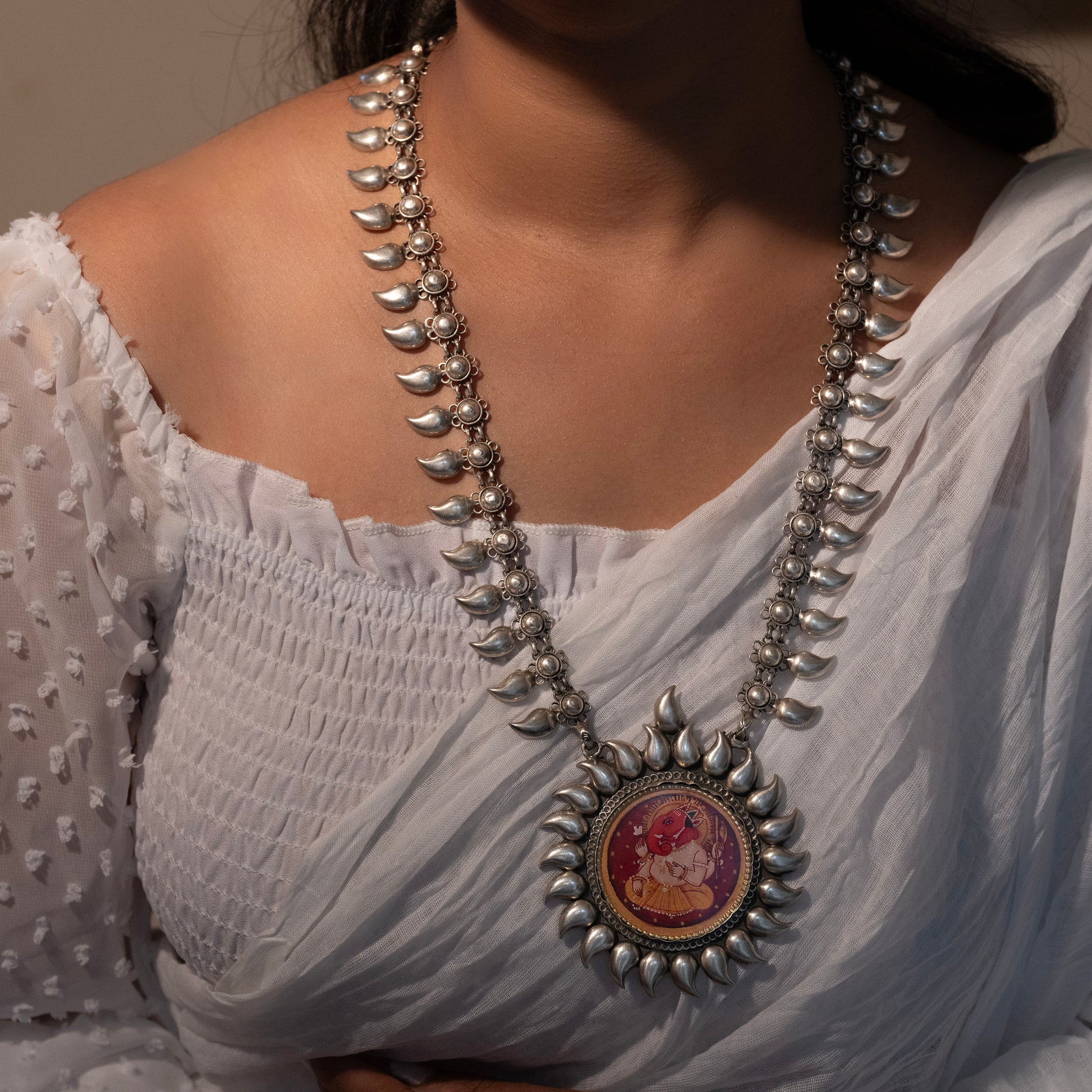 Elegant silver Ganpati print necklace with intricate detailing, featuring a delicate pendant of Lord Ganesha on a fine silver chain, perfect for a subtle yet divine statement