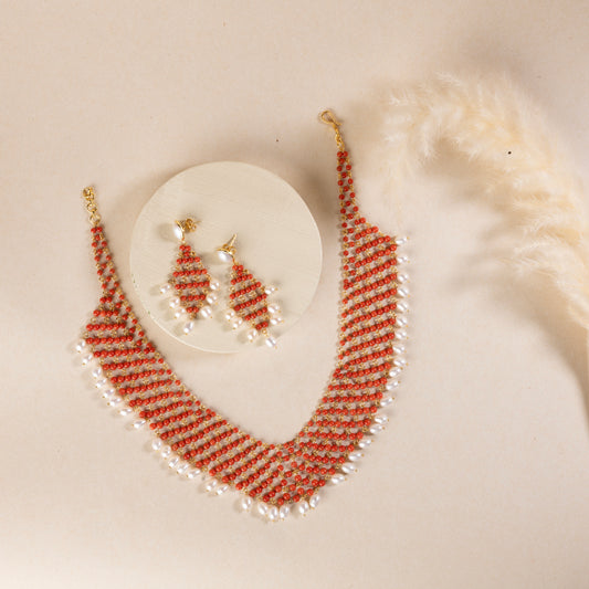 Statement coral necklace with dangling pearl stones, crafted in sterling silver with a gold finish. The necklace features vibrant coral and elegant pearls, creating a bold and luxurious design