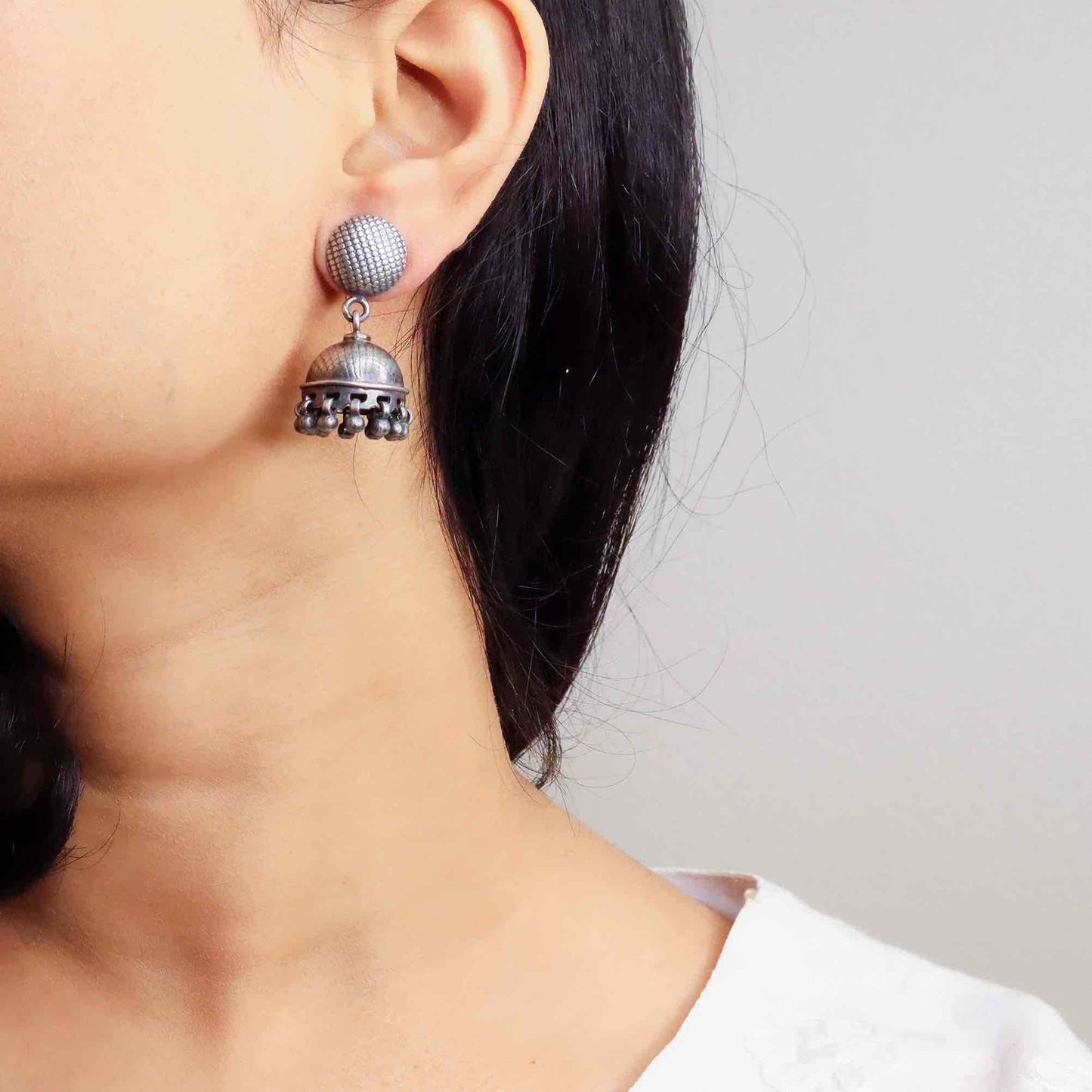 Intricately designed silver oxidized jhumka earrings with a traditional and vintage-inspired charm.