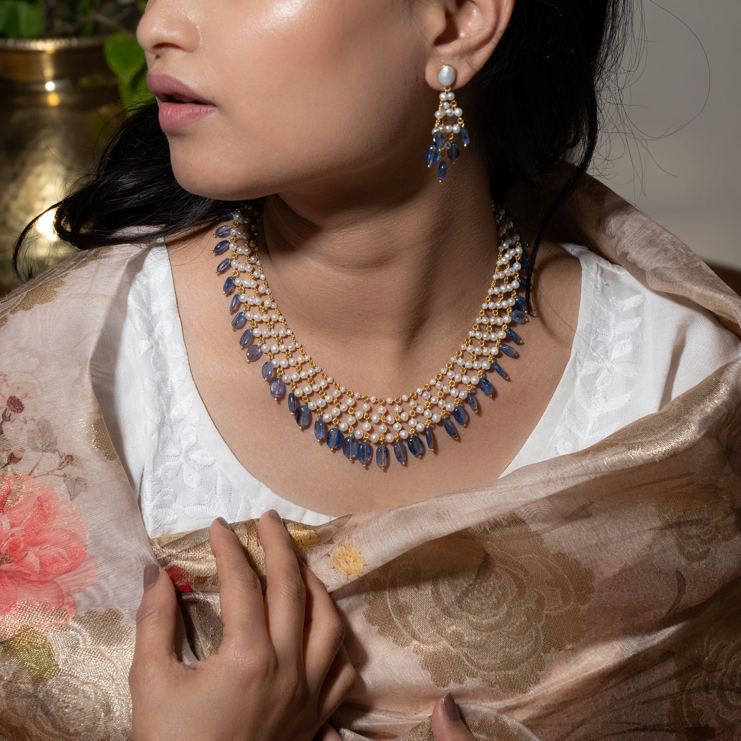 Statement pearl necklace with dangling kyanite stones, crafted in sterling silver with a gold finish. The necklace features lustrous pearls and vibrant blue kyanite stones, creating a bold and elegant piece