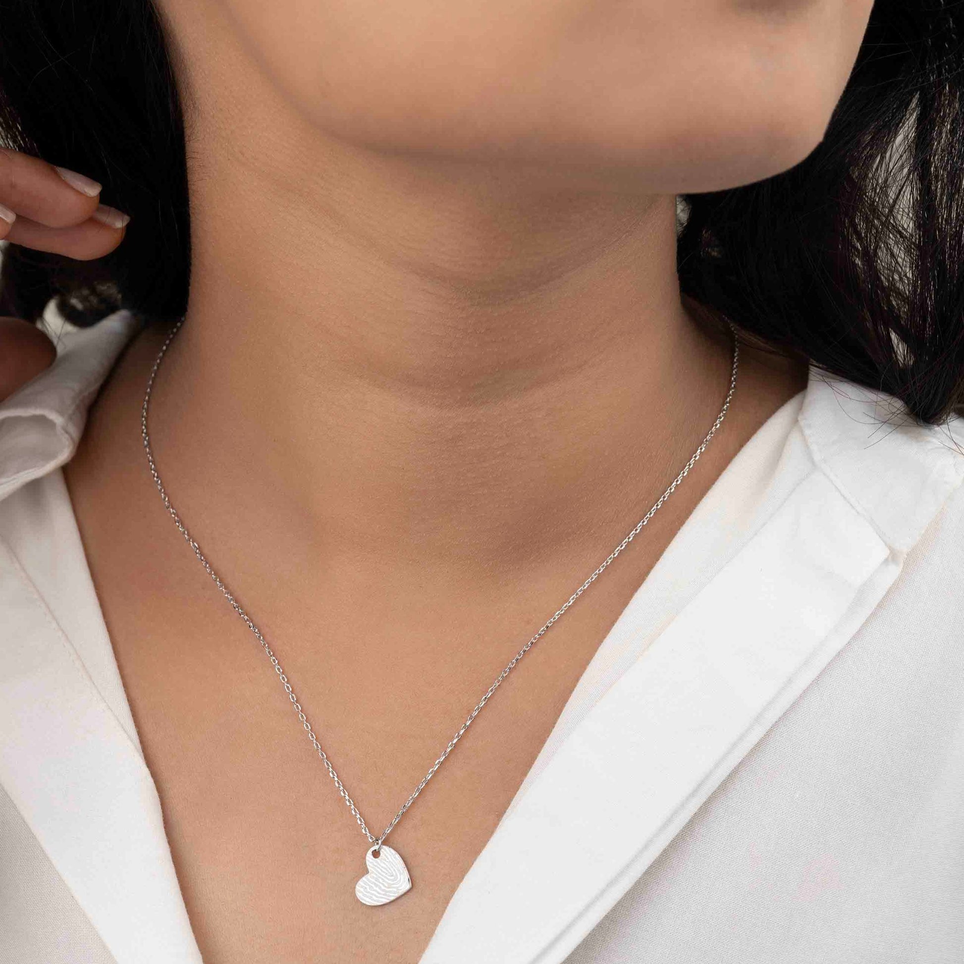 Elegant silver pendant necklace featuring a sleek, minimalist design, perfect for everyday wear."