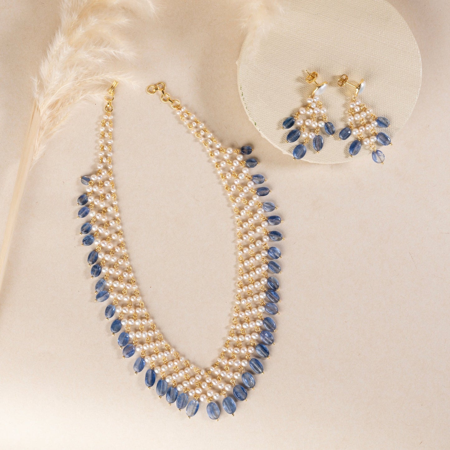 Statement pearl necklace with dangling kyanite stones, crafted in sterling silver with a gold finish. The necklace features lustrous pearls and vibrant blue kyanite stones, creating a bold and elegant piece