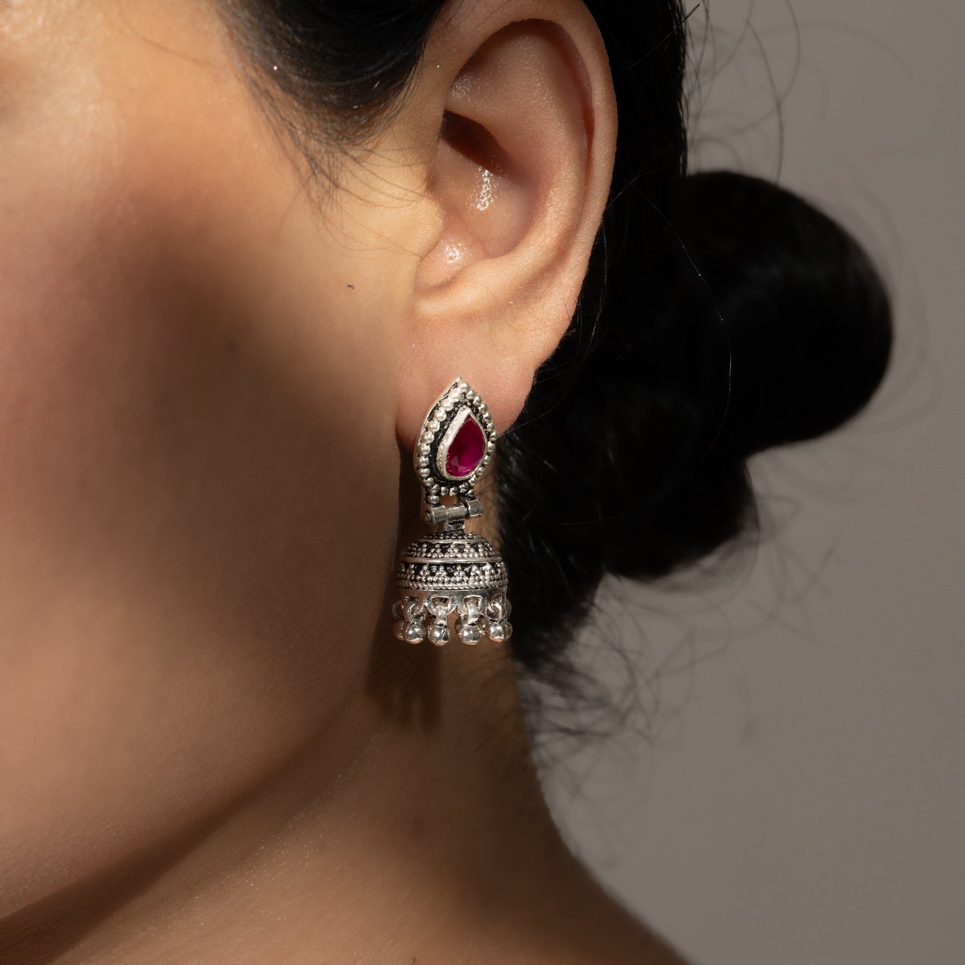 Intricately designed silver oxidized jhumka earrings with a traditional and vintage-inspired charm.