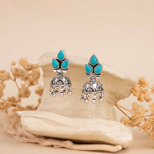 Silver earrings with turquoise stones on a beige background