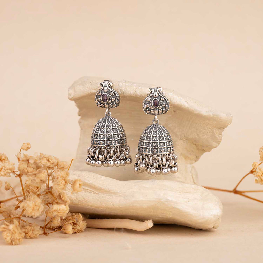 Silver earrings with gemstones on a natural stone background