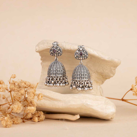 Silver earrings with gemstones on a natural stone background