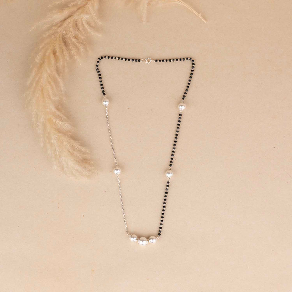 Necklace with black and clear beads on a beige background