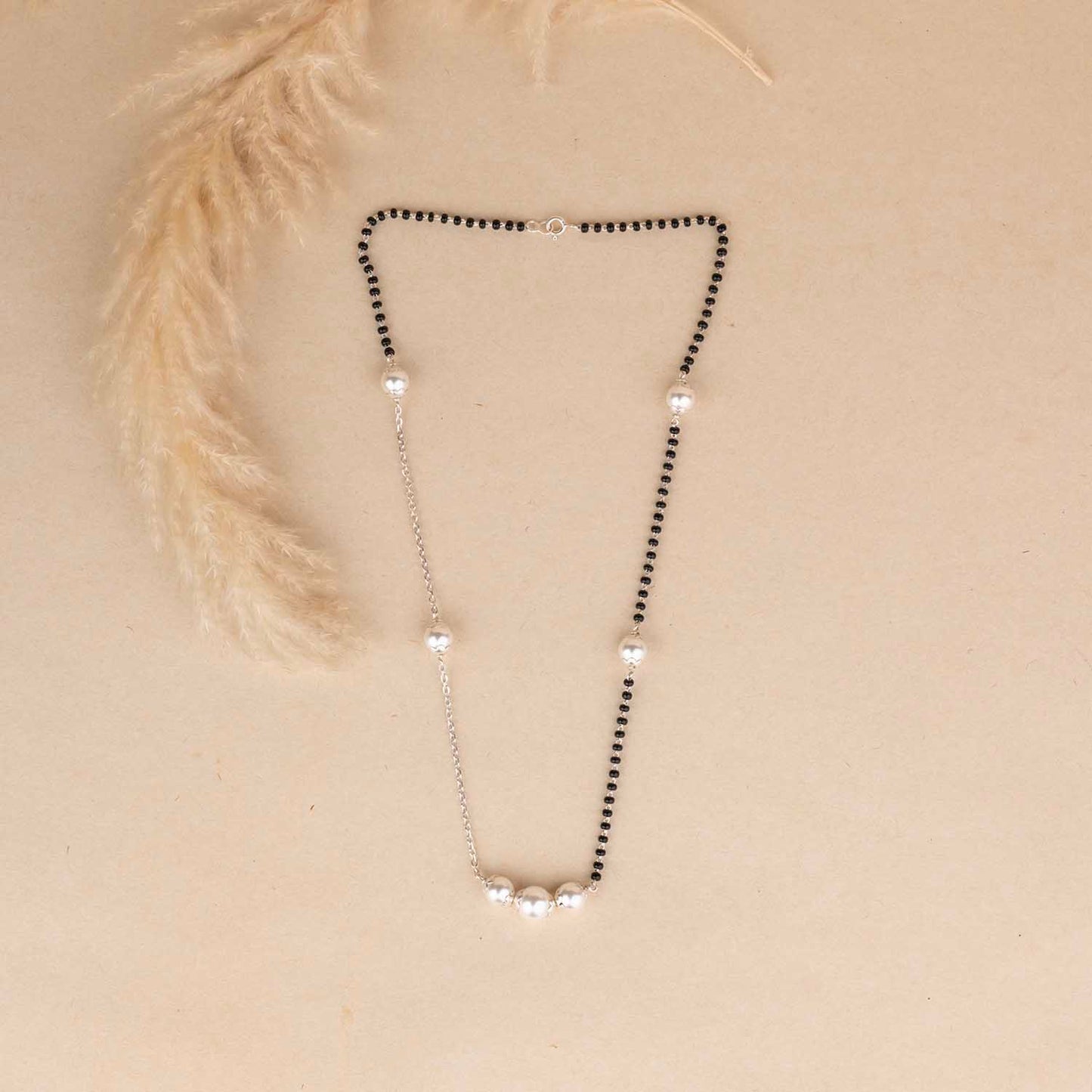 Necklace with black and clear beads on a beige background