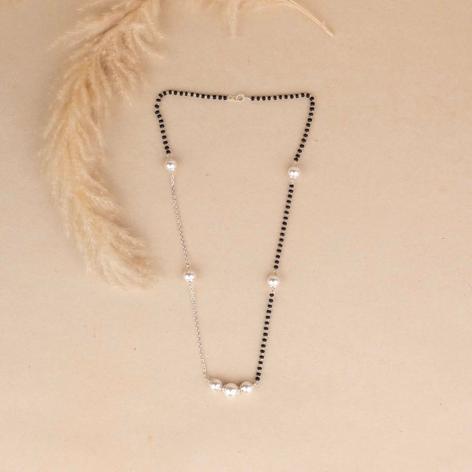 Necklace with black and clear beads on a beige background