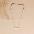 Necklace with black and white beads on a beige background