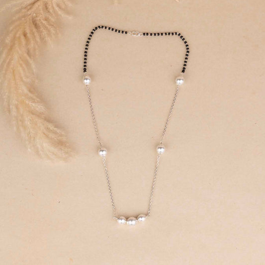 Necklace with black and white beads on a beige background