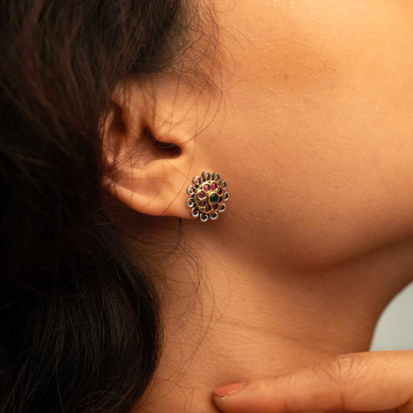 Close-up of a person wearing a decorative earring with a blurred background