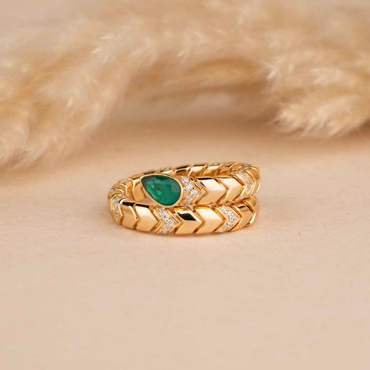 Gold ring with green gemstone on a beige fur background