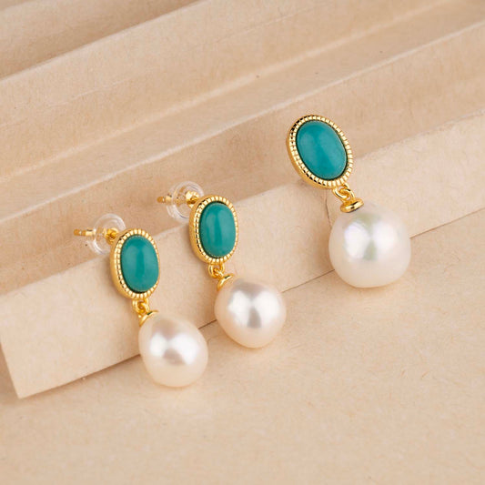 Pair of earrings with turquoise stones and pearls on a beige background