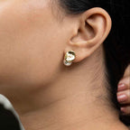 Close-up of an ear wearing a gold earring with a pearl center.