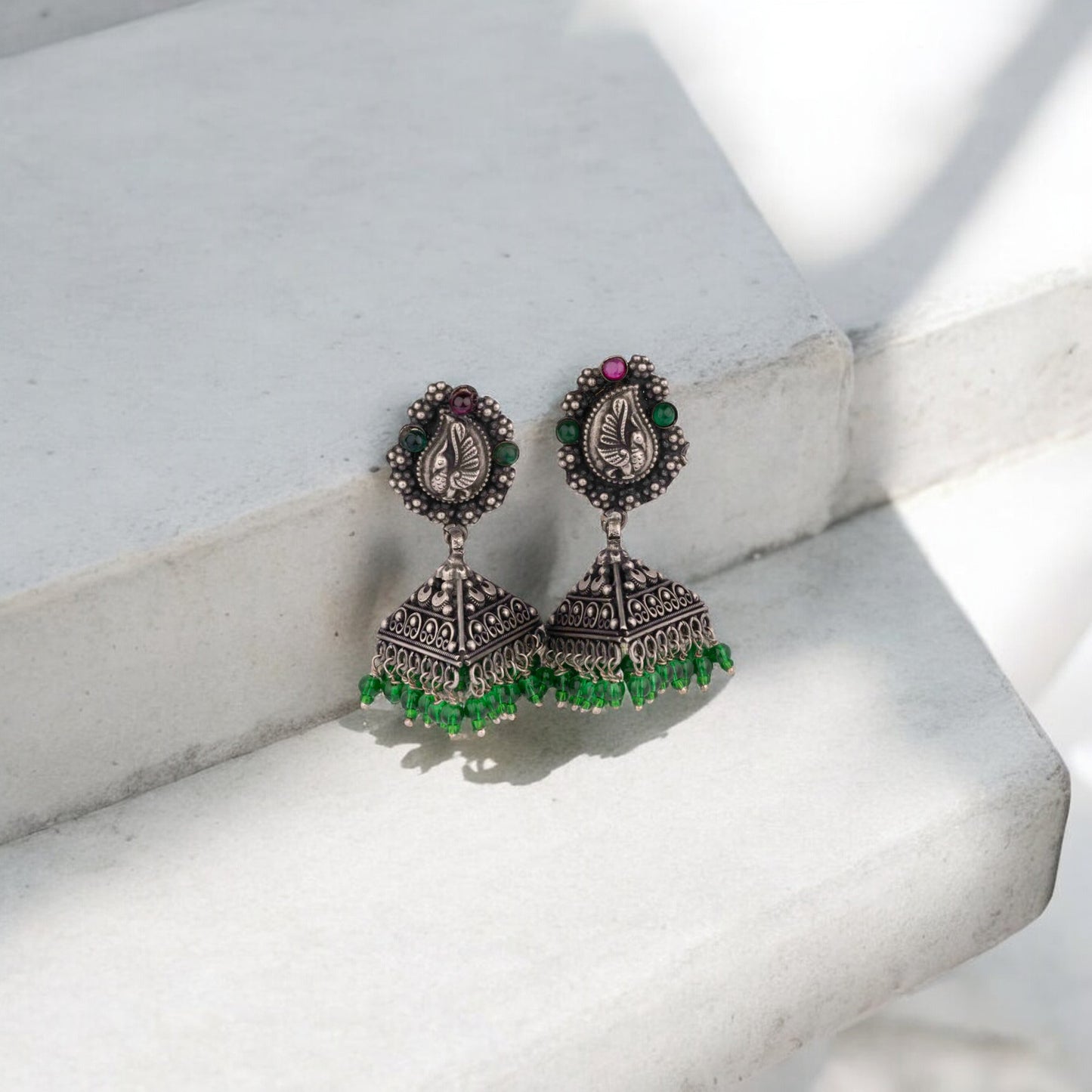 Intricately designed silver oxidized jhumka earrings with a traditional and vintage-inspired charm.