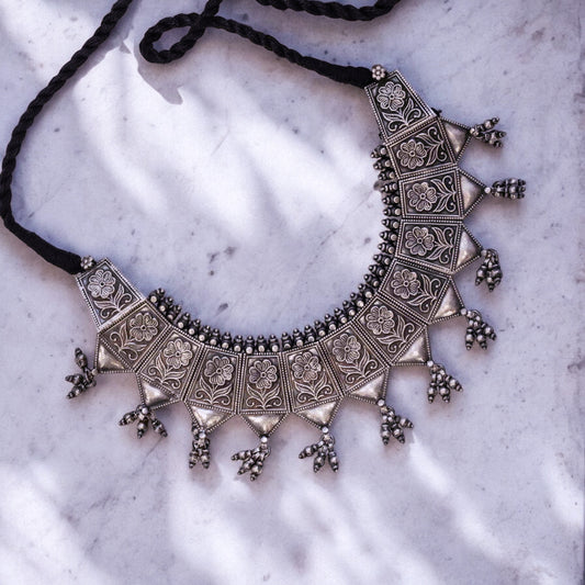 Striking oxidized silver necklace with detailed vintage-inspired patterns, offering a bold, unique look with a timeless, antique finish.